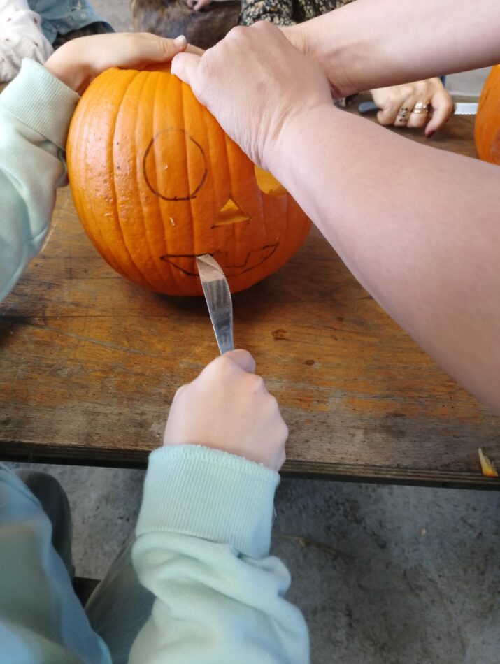 Enfant sculptant sa citrouille pour Halloween